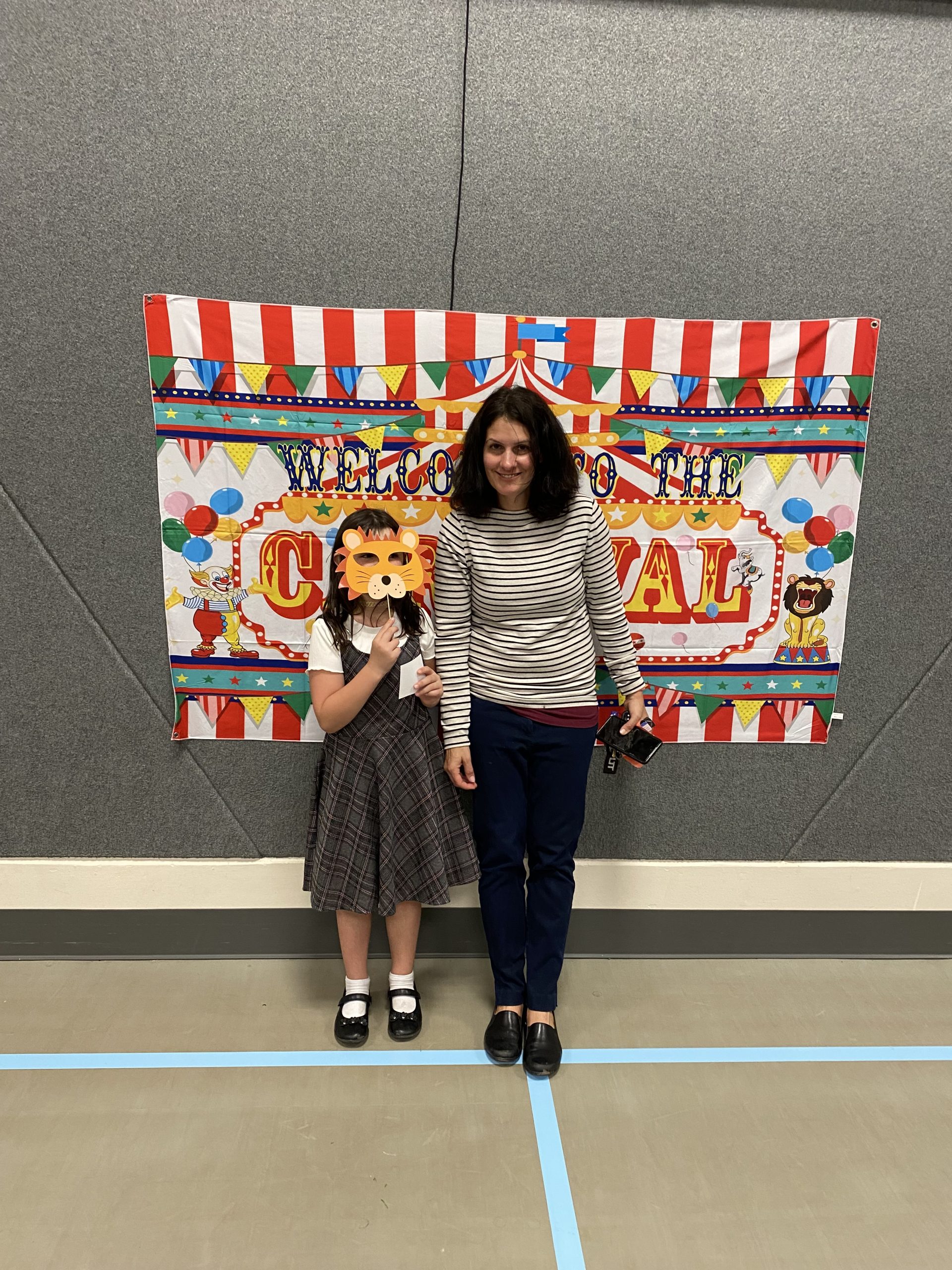 A mom and student with circus props at literacy Night
