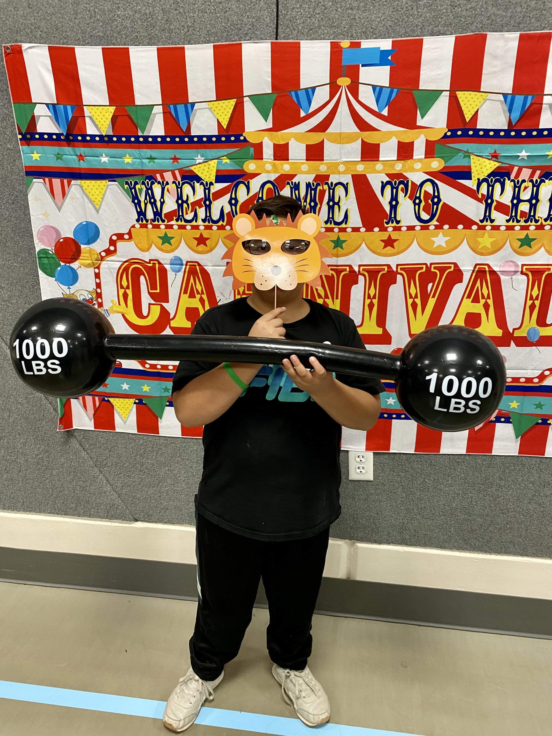 A student with a lion face prop at literacy night.